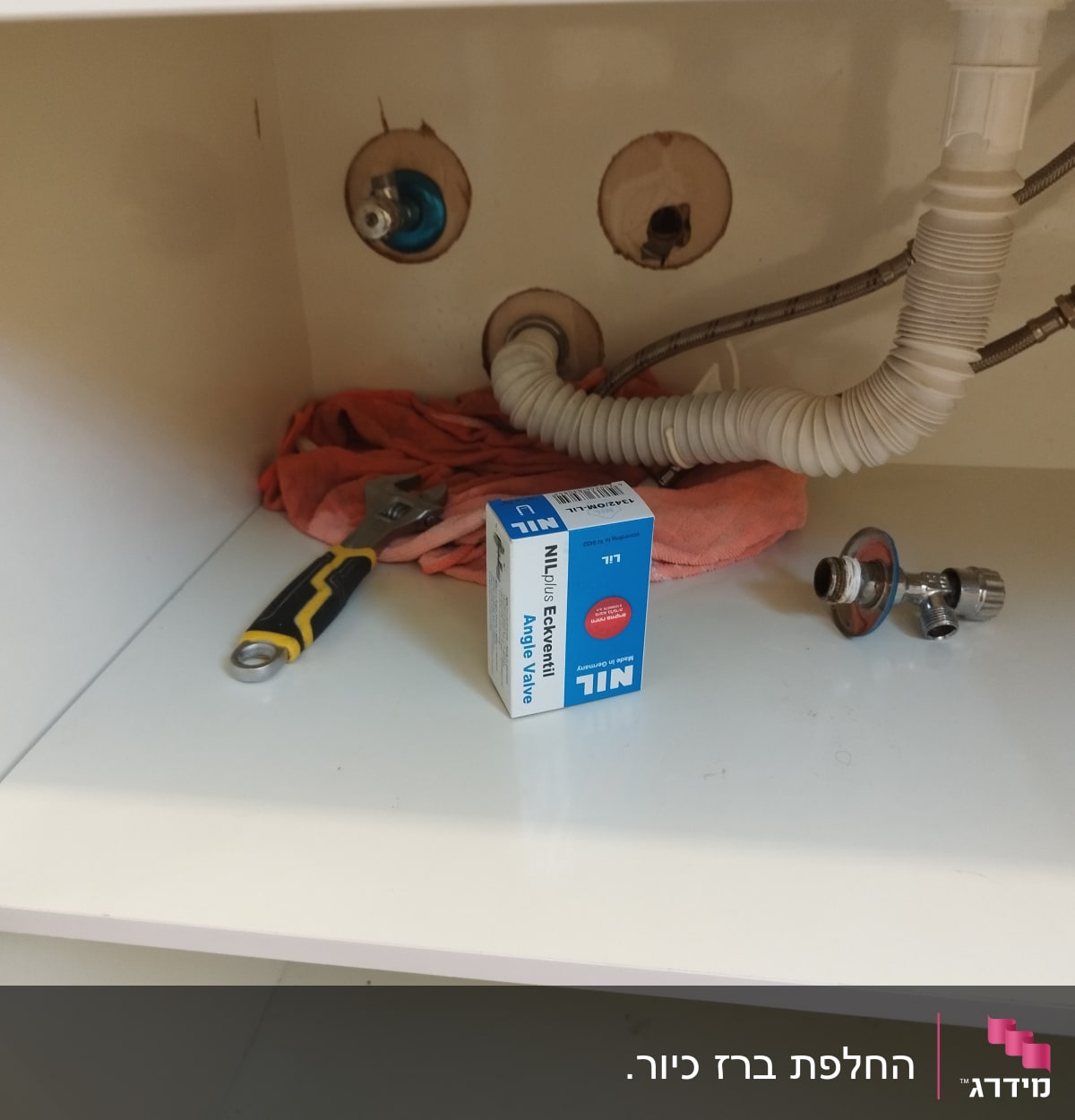 כלי עבודה וצינורות מתחת לכיור